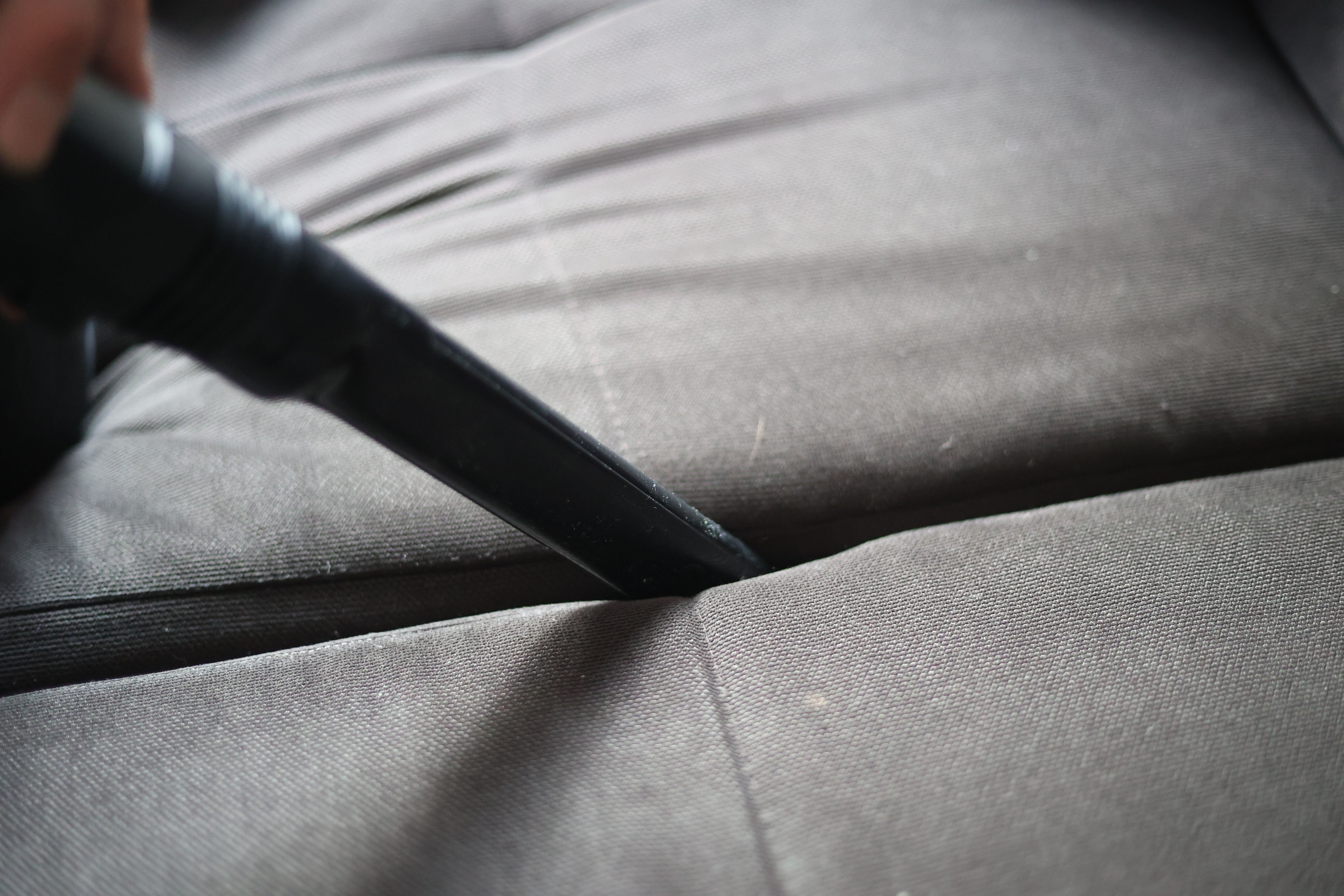 Cleaning the sofa seats with the crevice nozzle of the Shark Stratos.